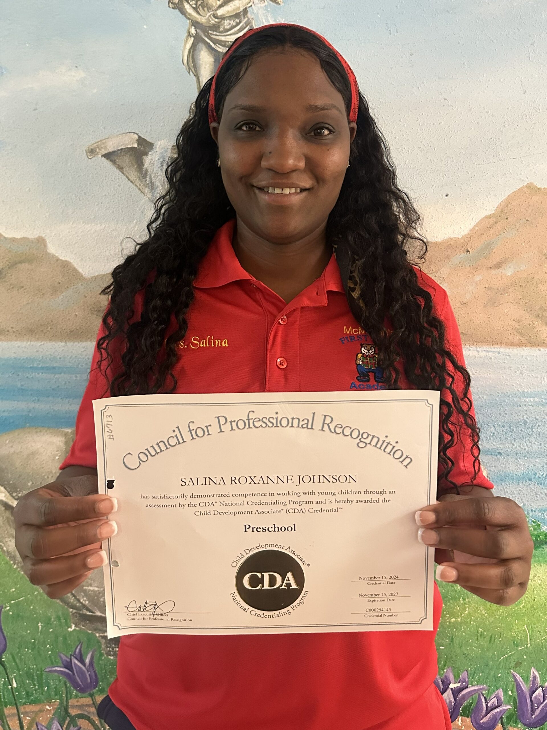 Salina Johnson, proudly holding up her Preschool CDA credentials.